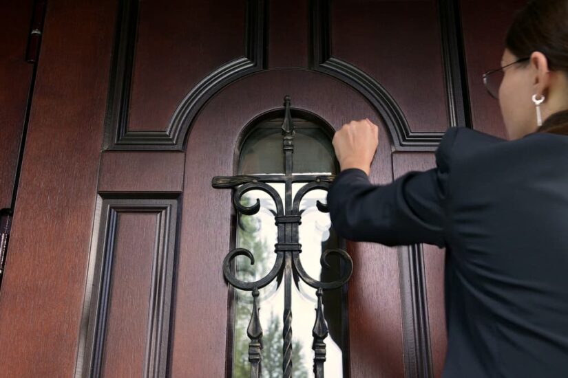 The woman and the state structure are persistently knocking on the door of a private house.
