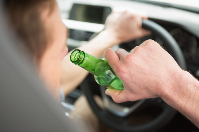 Photo of a Man Drinking Beer while Driving