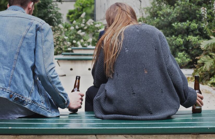 Underage alcoholism, young people drinking beer on the street