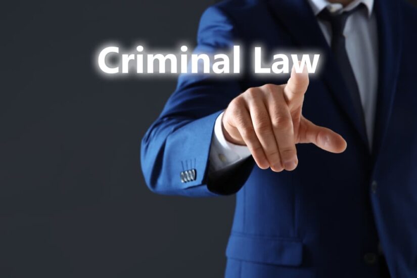 A man pointing on text CRIMINAL LAW against dark background