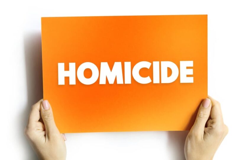 A orange color card hold by a person with text Homicide