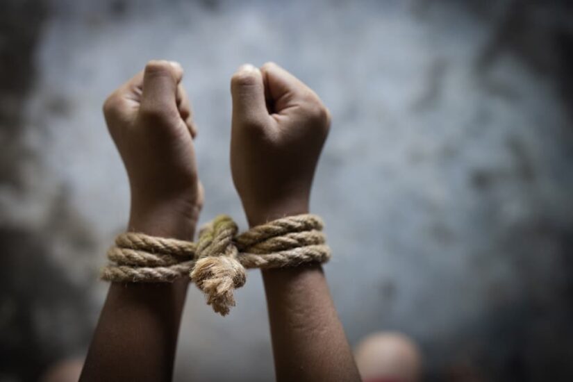 A kidnapped man hands tied together with rope.
