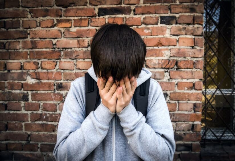 Photo of Sad Teenager by the Brick Wall