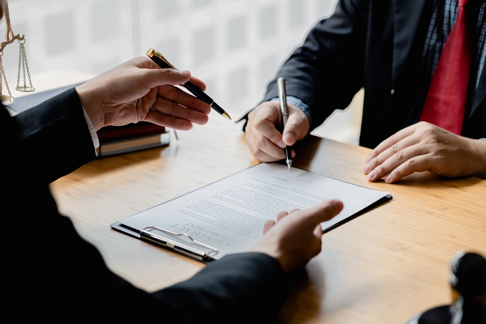 Criminal defense attorney meeting with a client to review paperwork.